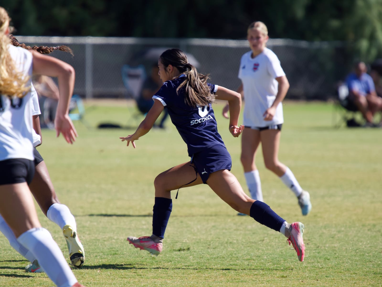 Midfielder driving past a Davis Legacy defender